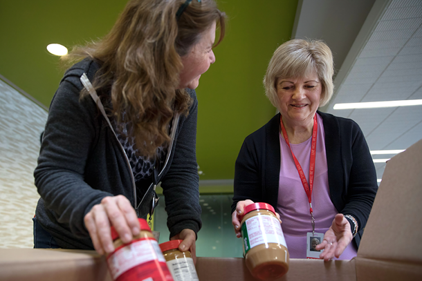 Employees collecting peanut butter for volunteer food drive