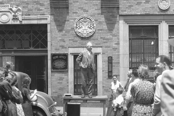 G.J. Mecherle standing on his desk, giving a speech